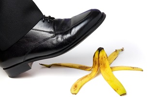 man’s foot about to slip on banana peel